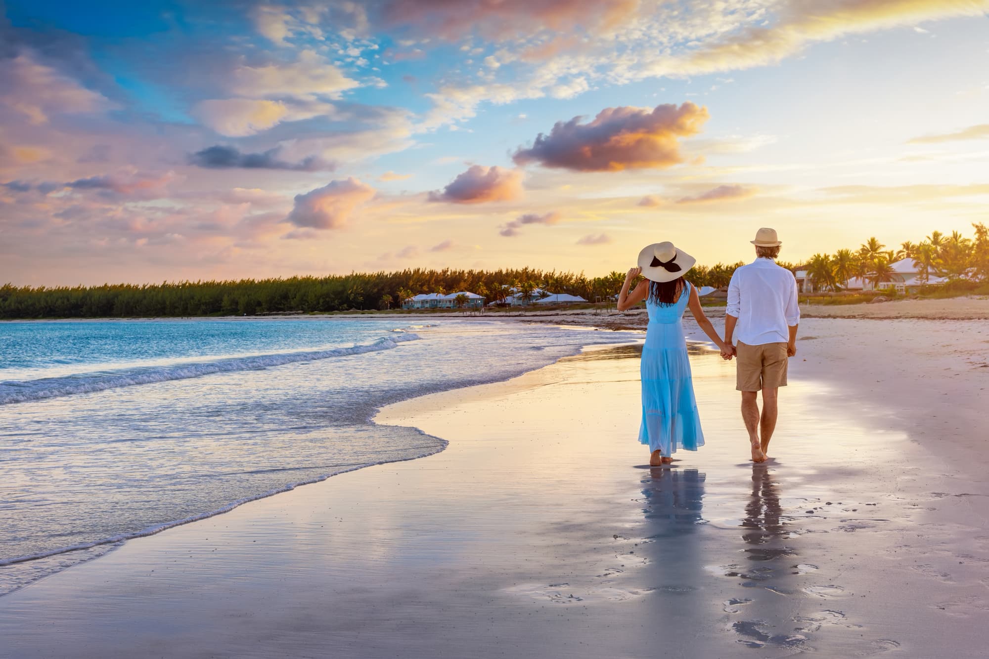 Couple walking on a beach during a private jet vacation